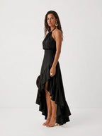 Elegante vestido de invitada de boda con negro cuello halter y bajo asimétrico de volantes