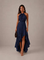 Elegante vestido de invitada de boda azul con cuello halter y bajo asimétrico de volantes