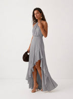 Elegante vestido de invitada de boda gris con cuello halter y bajo asimétrico de volantes