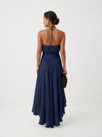 Elegante vestido de invitada de boda azul con cuello halter y bajo asimétrico de volantes