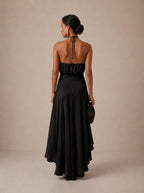 Elegante vestido de invitada de boda con negro cuello halter y bajo asimétrico de volantes