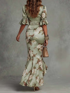 Loretta | Vestido Largo Asimétrico en Satén Verde con Escote en V, Mangas Abullonadas Acampanadas y Estampado Floral