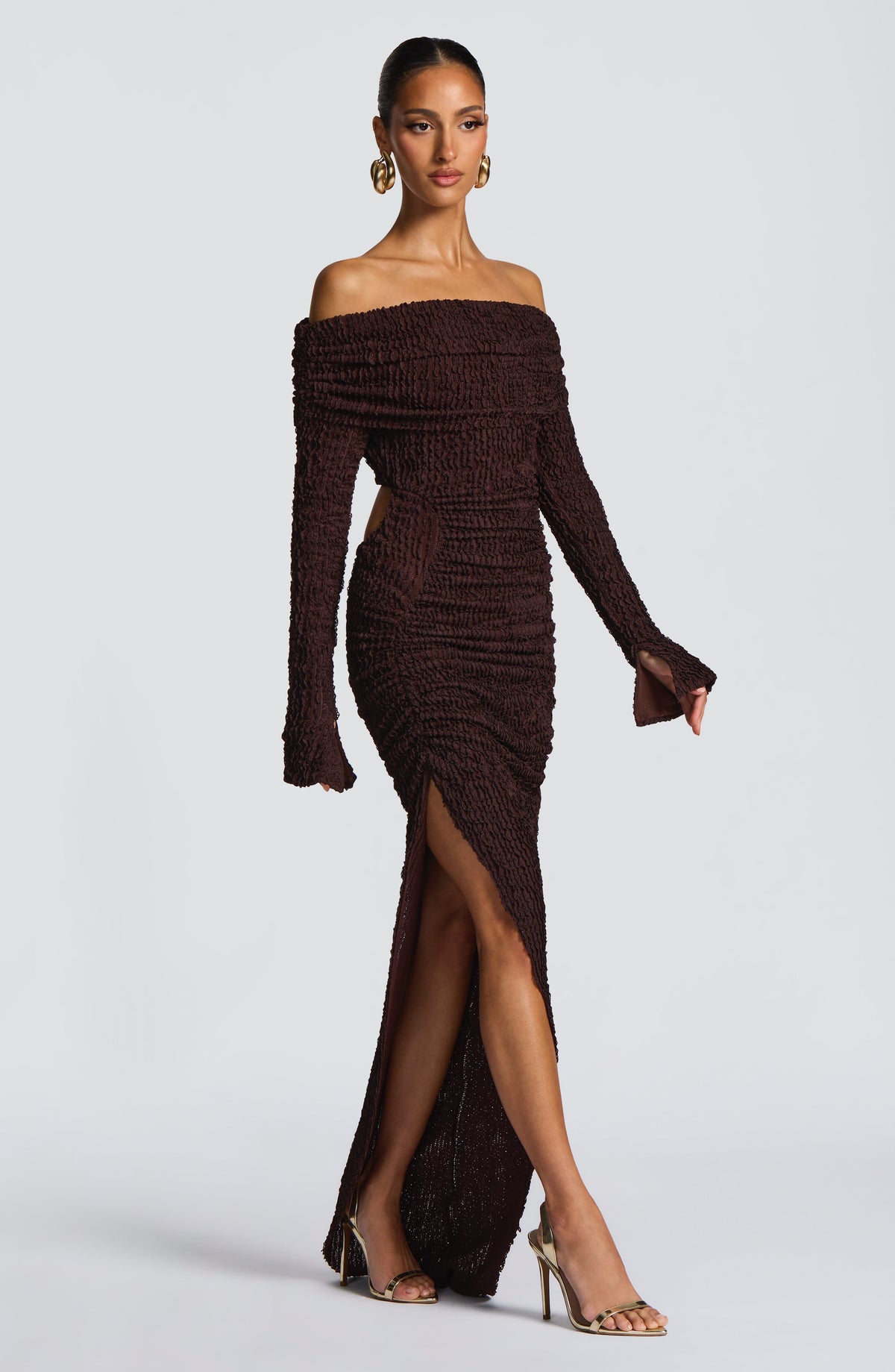 Refinado vestido marrón de invitada de boda con escote bardot manga larga y abertura | Largo