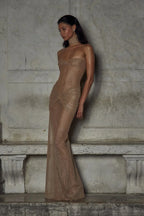 Refinado vestido largo beige palabra de honor de invitada de boda con acabado brillante y plisado | Maxi
