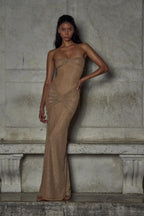 Refinado vestido largo beige palabra de honor de invitada de boda con acabado brillante y plisado | Maxi
