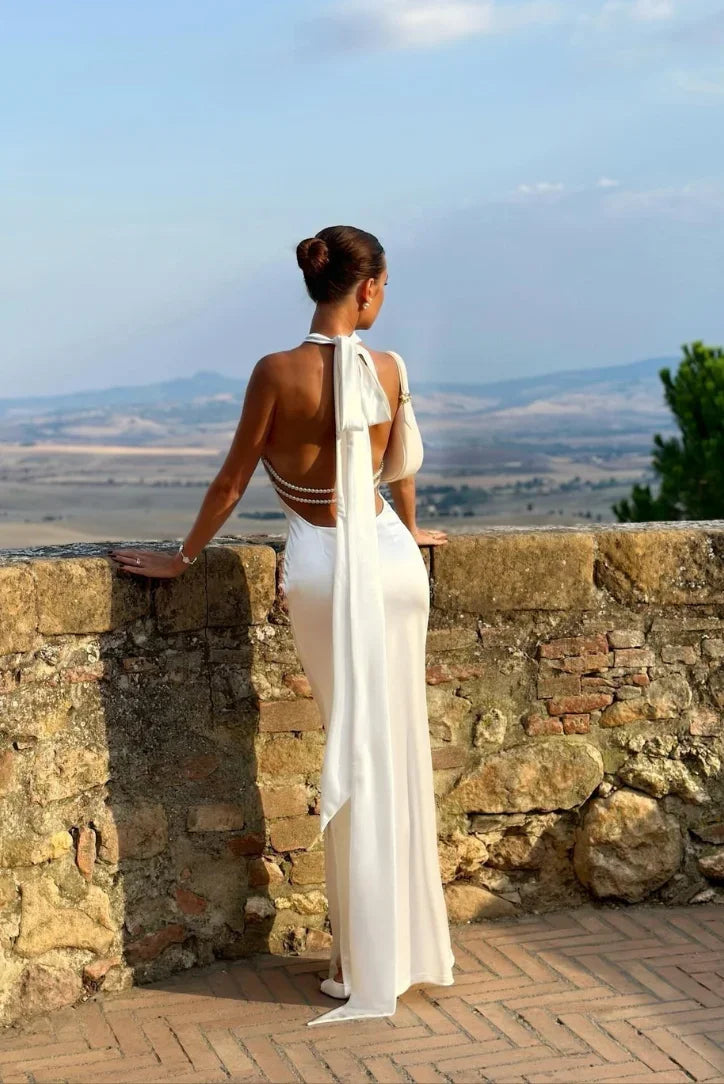 Sofisticado vestido largo blanco de invitada de boda con espalda descubierta y detalles de perlas | Maxi