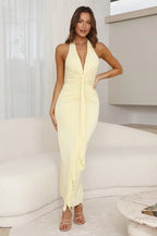 Radiante vestido largo amarillo de invitada de boda con cuello halter y pliegues fluidos | Maxi